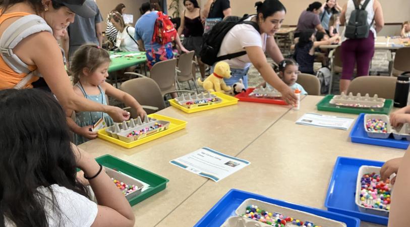Tables set-up with activities for pre-kindergarteners and caregivers